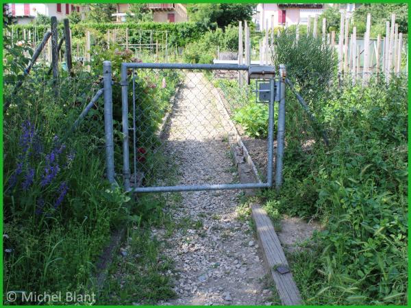 Portail de jardin avec un espace entre le portail et le sol